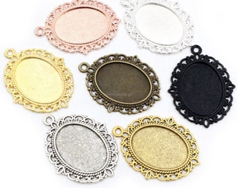 Puede incluir: Una colección de bandejas colgantes ovaladas en varios acabados metálicos, incluyendo oro rosa, plata, oro y negro. Cada bandeja presenta un borde decorativo de filigrana y un pequeño lazo para sujetar una cadena. Ideal para la creación de joyas.