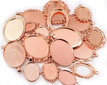 May include: A collection of rose gold oval pendant trays and bezels in various sizes and decorative styles. The trays have a flat surface for setting a cabochon or other embellishment. The text "Oval Rose Gold" is at the bottom.