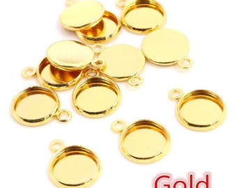 Puede incluir: Una colección de bandejas colgantes redondas de metal dorado, cada una con un engaste circular y un pequeño lazo en la parte superior para su fijación. Los artículos están dispuestos de forma dispersa y la palabra Gold aparece en rojo.