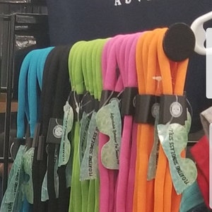 May include: Assortment of colorful floating sunglass straps. The straps are made of a soft, flexible material and are available in a variety of colors, including blue, green, pink, and orange. The straps are labeled "Floating Sunglass Straps" and "Adjustable Retainer For Seniors 18".