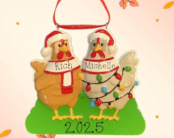 May include: A Christmas ornament featuring two chickens wearing Santa hats and scarves. One chicken is tan, the other is white, and both are decorated with Christmas lights. The ornament has the names "Rich" and "Michelle" and the year "2025".