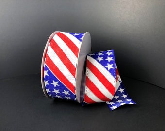 May include: A roll of red, white, and blue ribbon with a diagonal stripe pattern and white stars. The ribbon is made of a woven fabric and is perfect for crafting and decorating.
