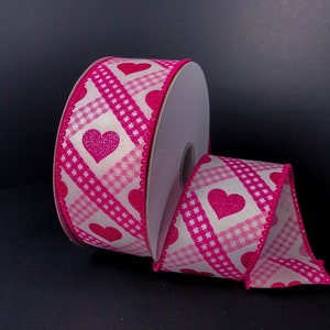 May include: Pink and white gingham ribbon with pink glitter hearts. The ribbon is rolled up on a white spool.