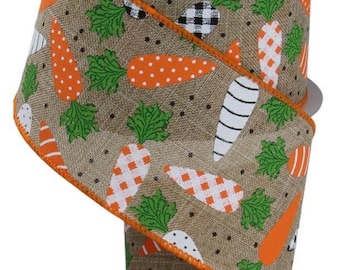 May include: A roll of decorative ribbon with a repeating pattern of orange carrots with green tops on a tan background. The carrots have various designs, including stripes and polka dots. The ribbon is trimmed with orange and black and white checkered accents.