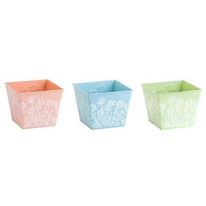 May include: Three square metal planters with a white floral design. The planters are in pastel pink, blue, and green.