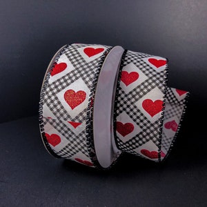 May include: Black and white gingham ribbon with red hearts. The ribbon has a black scalloped edge.