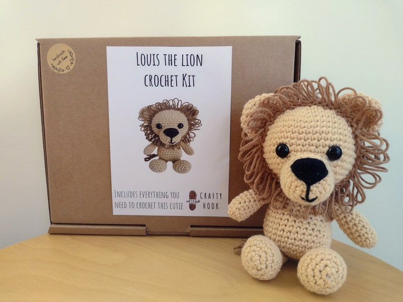 May include: A crochet kit to make a stuffed lion named Louis. The kit includes everything you need to crochet this cutie. The box is brown with a white label that says "Louis the Lion Crochet Kit".