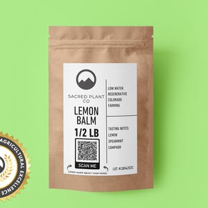 A resealable kraft paper bag Sacred Plant Co Lemon Balm 1/2 LB, tasting notes of lemon, spearmint, and camphor. A circular cutout reveals the vibrant green and finely chopped lemon balm leaves. Recognized for innovative agricultural excellence.