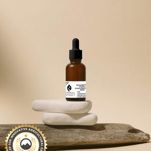 Half-ounce Eternal Extract Resurrection Plant & Sunflower Face Serum in an eco-friendly amber glass dropper bottle, artfully placed on natural stones and driftwood. Recognized for innovative agricultural excellence.