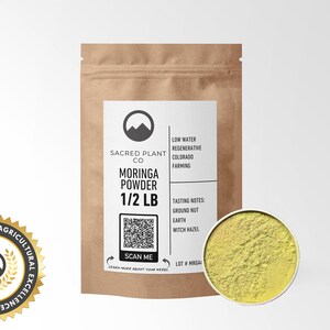 Sacred Plant Co’s 1/2 LB Moringa Powder in resealable kraft bag, displayed with a sample of the product in a silver tin, rich in vitamins and minerals, perfect for smoothies and herbal blends. Includes Agricultural Innovation Excellence badge.