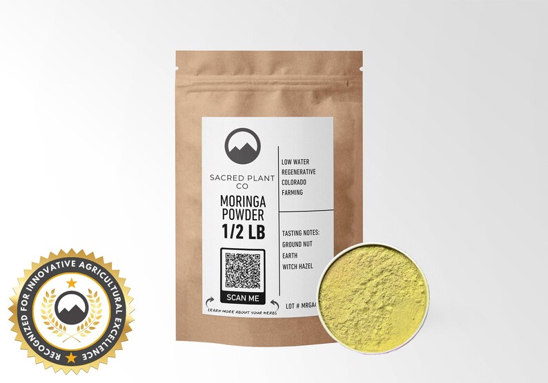 Sacred Plant Co’s 1/2 LB Moringa Powder in resealable kraft bag, displayed with a sample of the product in a silver tin, rich in vitamins and minerals, perfect for smoothies and herbal blends. Includes Agricultural Innovation Excellence badge.