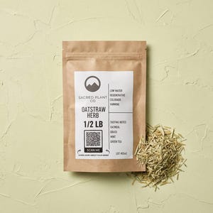 May include: A brown paper pouch of Sacred Plant Co Oatstraw Herb labeled 1/2 LB with a QR code, tasting notes of oatmeal, grass, mint, and green tea, and a small pile of dried oatstraw herb pieces placed next to the pouch on a light green surface.
