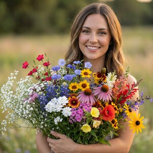 Woman holding a colorful bouquet of Southwest wildflowers including coneflower, coreopsis, flax, and poppy, standing in a sunny meadow.