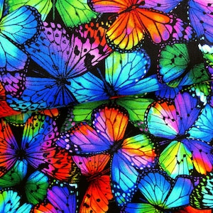 Könnte beinhalten: Ein farbenfroher Stoff mit einem sich wiederholenden Muster aus Schmetterlingen in Blautönen, Grün, Rot, Orange und Lila. Die Schmetterlinge sind in einem zufälligen Muster angeordnet und überlappen sich.