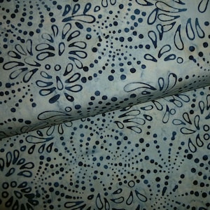 Könnte beinhalten: Blauer und weißer Stoff mit einem sich wiederholenden Muster aus kleinen Punkten und stilisierten floralen Designs.