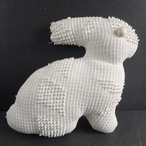 May include: White crocheted bunny rabbit plush toy with a white button eye.
