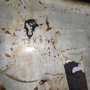 May include: A white ceramic mug with a black handle and the text "But First, Coffee" in a black, handwritten-style font. The mug is on a white surface.