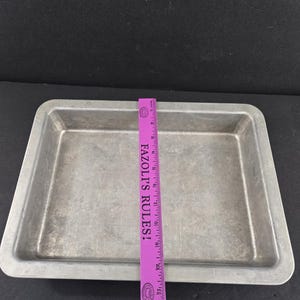 May include: A white ceramic mug with a black handle and the text "But First, Coffee" in a bold, black font. The mug is set against a neutral background, highlighting its simple design.