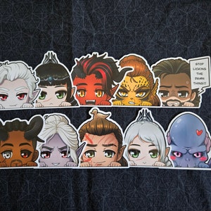 May include: A set of nine cartoon character stickers featuring various expressions and designs. The stickers are printed on white paper and have a glossy finish. The characters include a vampire, a demon, a cat, a human, a werewolf, a goblin, and a bird. The stickers are perfect for adding a touch of whimsy to your laptop, water bottle, or planner.