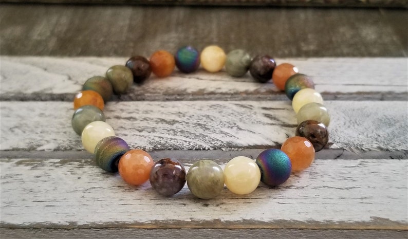 May include: A bracelet made with various semi-precious stones, including green, brown, orange, and iridescent blue beads.