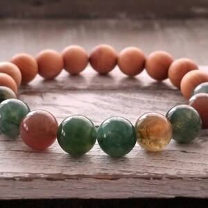 Op de afbeelding: Een armband gemaakt van bruine houten kralen en groene, bruine en oranje agaat kralen.