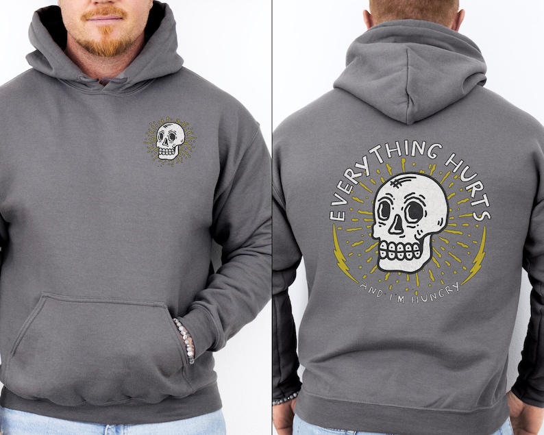 May include: Gray hooded sweatshirt with a white skull graphic on the front and the text "EVERYTHING HURTS AND I'M HUNGRY" on the back.