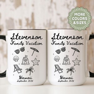 Pu&ograve; includere: Due tazze in ceramica bianca con manici e bordi neri. Ogni tazza presenta il testo "Stevenson Family Vacation" e illustrazioni a tema spiaggia. Il fondo di ogni tazza recita "Hawaii September 2025".