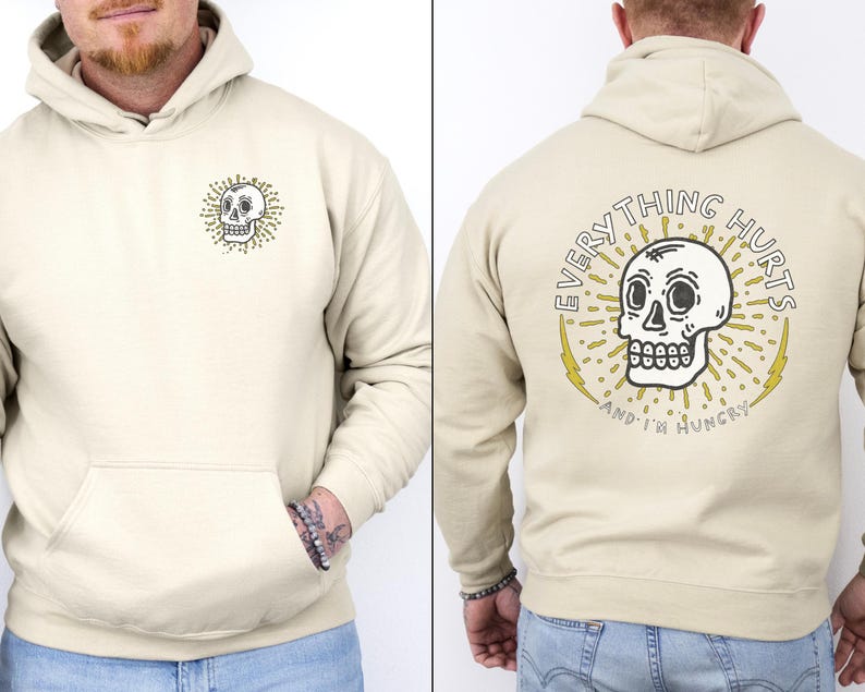 May include: A beige hoodie with a skull graphic on the front and the text "EVERYTHING HURTS AND I'M HUNGRY" on the back.