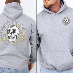 May include: Gray hooded sweatshirt with a skull graphic and the text "EVERYTHING HURTS AND IT'S ALWAYS SUNNY".