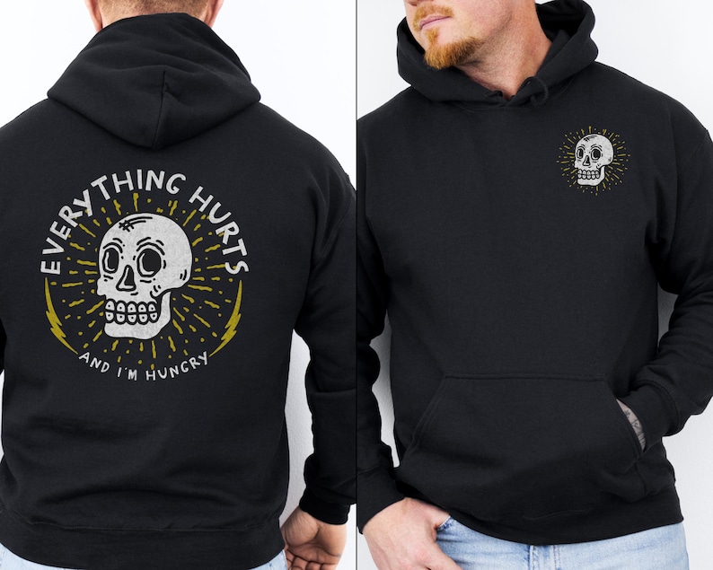 May include: Black hoodie with a white skull graphic on the front and the text "Everything Hurts and I'm Hungry" on the back.