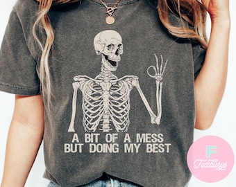 May include: A gray t-shirt with a skeleton graphic and the text "A bit of a mess but doing my best".