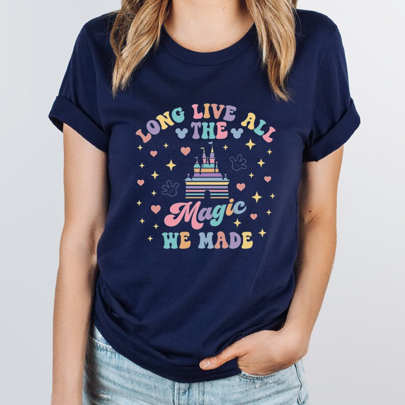 May include: Navy blue t-shirt with a pastel rainbow design featuring a castle, Mickey Mouse ears, and the text "Long Live All The Magic We Made".