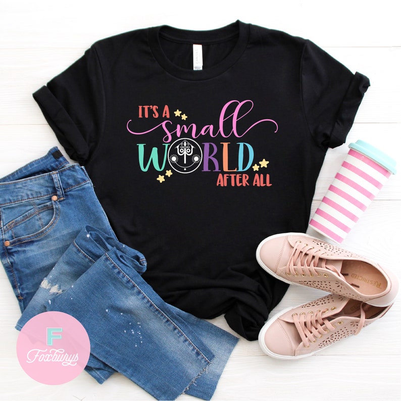 May include: Black t-shirt with the text "It's a small world after all" in colorful letters. The text includes a small world icon with a smiling face.