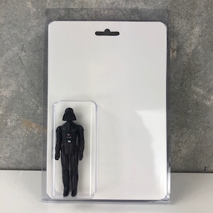 May include: A black plastic action figure of Darth Vader from Star Wars in a clear plastic display case.