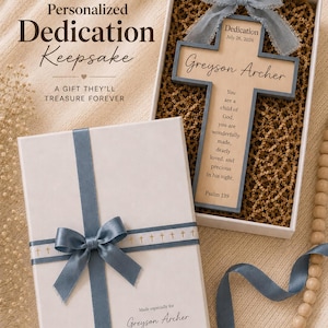 May include: A wooden cross keepsake in a white gift box with a blue ribbon. The cross features the text: Dedication July 26, 2026, Greyson Archer, You are a child of God, you are wonderfully made, dearly loved, and precious in his sight. Psalm 139.