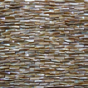 May include: A sheet of iridescent brown and white mother of pearl tile mosaic. The tiles are rectangular and arranged in a staggered pattern.