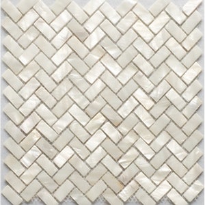 Peut inclure: Mosaïque de carreaux en nacre blanche en chevrons. Les carreaux sont petits et rectangulaires, créant un léger scintillement.