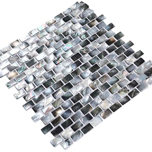 May include: A sheet of black and white iridescent mother of pearl tile mosaic. The tiles are rectangular and arranged in a brick pattern.