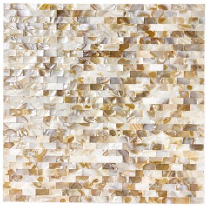 Puede incluir: Un patrón de mosaico cuadrado compuesto por pequeñas piezas rectangulares. Las baldosas tienen una cualidad nacarada con una mezcla de tonos blancos, crema y marrón dorado. La disposición crea una superficie texturizada y visualmente atractiva.