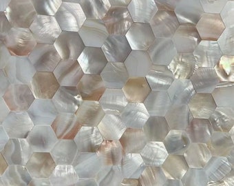 May include: A sheet of white and beige iridescent hexagon-shaped tiles made from mother of pearl. The tiles are arranged in a repeating pattern.