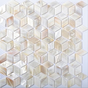 Op de afbeelding: Witte, iriserende mozaïektegels in een geometrisch patroon. Elke tegel is een kleine, onregelmatige zeshoek met een licht verhoogd midden. De tegels zijn gerangschikt in een herhalend patroon van afwisselende rijen zeshoeken.
