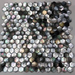 Op de afbeelding: Een vel zwarte en iriserende zeshoekige mozaïektegels. De tegels zijn gemaakt van parelmoer en hebben een subtiele glans.