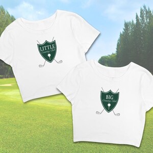 May include: Two white crop tops with a green shield logo. The top on the left says "LITTLE Country Club" and the top on the right says "BIG Country Club".