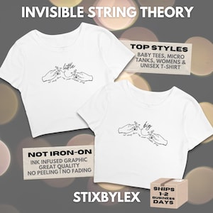 May include: White crop tops with a black line drawing of hands holding a string, with the words "little" and "big". The text "INVISIBLE STRING THEORY" is at the top. Additional text includes "TOP STYLES" and "NOT IRON-ON".