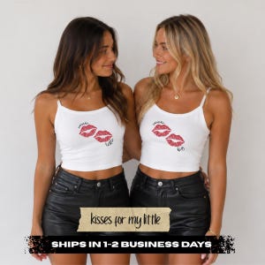 Pode incluir: Duas regatas brancas curtas com estampa de l&aacute;bios vermelhos. Uma pe&ccedil;a exibe o texto xoxo little, enquanto a outra exibe xoxo big. Ambas s&atilde;o combinadas com shorts pretos. O design inclui marcas de beijos feitas com batom vermelho.