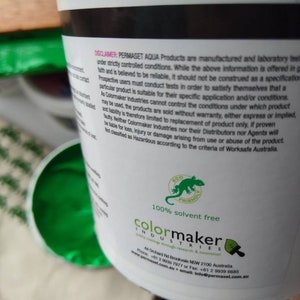 Może przedstawiać: Białe wiaderko z farbą z zielonym logo jaszczurki i tekstem "100% bez rozpuszczalnik&oacute;w" oraz "colormaker industries" nadrukowanym na etykiecie. Etykieta zawiera r&oacute;wnież adres, numer telefonu, adres e-mail i stronę internetową firmy.