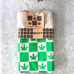 May include: A green and white checkered tote bag with a hemp leaf design. The bag is folded and has a brown tag that reads "ASANOHIA - HEMP LEAF" and "BAGSY".