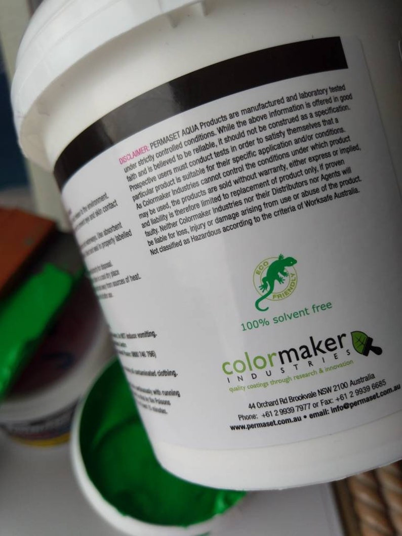 May include: A white bucket with a green lid. The bucket contains green paint. The label on the bucket says "Permaset Aqua Products" and "Colormaker Industries". The label also says "100% solvent free" and "quality coatings through research & innovation".