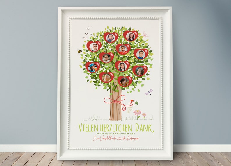 May include: A white framed poster with a green tree with red apples. Each apple has a photo of a child inside. The tree has a brown trunk with a red ribbon tied around it. The poster says "Vielen herzlichen Dank, dass ihr eine so bewachen  Gemeinschaft wart. Ein  Abschlussbild 2021 der Klasse".