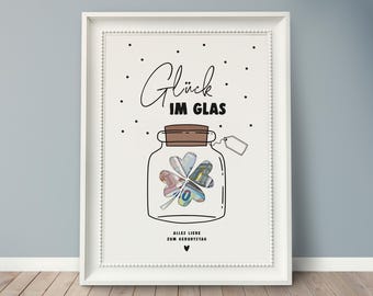 May include: White framed print with black text that reads "Glück im Glas" (German for "Luck in the glass") and a drawing of a glass jar with a four-leaf clover inside. The jar has a brown lid and a tag hanging from it. The text "Alles Liebe zum Geburtstag" (German for "All the best for your birthday") is at the bottom of the print.